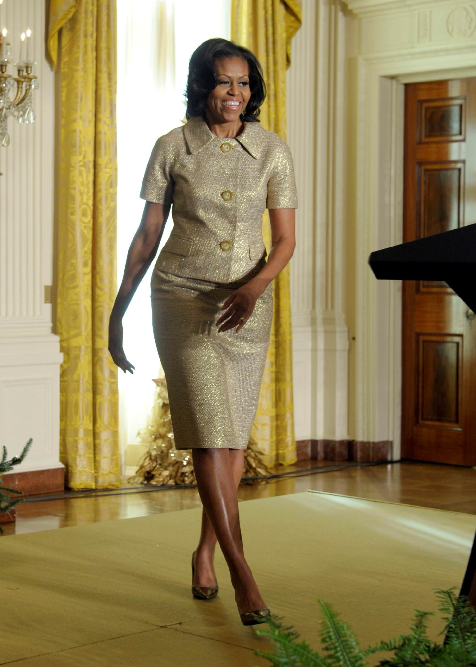 First lady Michelle Obama walks up to the microphone to speaks in the East Room of the White House in Washington, Wednesday, Nov. 28, 2012, to welcome military families during a preview of the White House holiday decorations. The theme for the White House Christmas 2012 is Joy to All. (AP Photo/Susan Walsh)